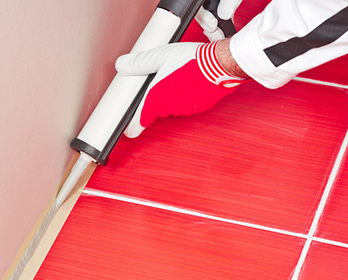 Picture of a Red Tile Floor with White Grout Lines and Caulking